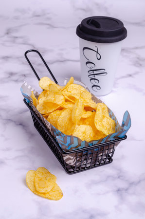 Potato chips in a basket on a marble background. Selective focus.