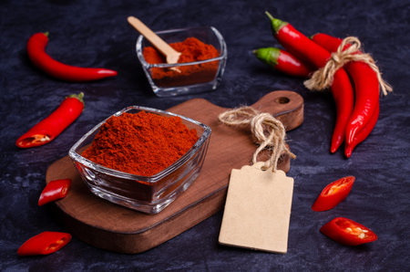 Red pepper powder in a bowl on a dark stone background. Selective focus.