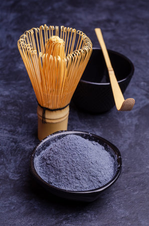 Traditional blue tea powder on a dark background. Selective focus.