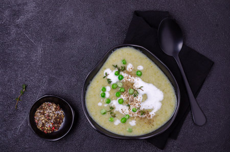 Thick vegetable soup with yogurt on a black stone background. Selective focus