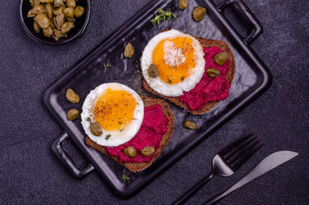 Sandwich with beetroot sauce and egg on a stone background. Top view. Selective focus.の写真素材