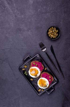Sandwich with beetroot sauce and egg on a stone background. Top view. Selective focus.の写真素材