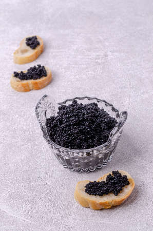 Organic black caviar in a dish on a light background. Selective focus.の写真素材