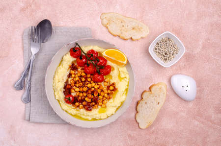 Mashed potatoes with chickpeas and vegetables on a cement background. Selective focus.の写真素材