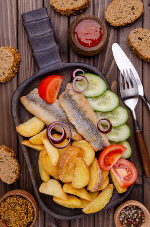 Fish fillet with fried potatoes and fresh vegetables. Selective focus.の写真素材