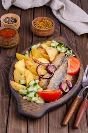 Fish fillet with fried potatoes and fresh vegetables. Selective focus.の写真素材