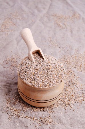 Dry white chia seeds in a wooden bowl on a textile background. Selective focus.の写真素材