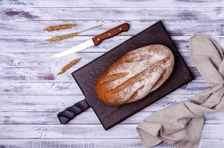 Traditional dark bread on a light wooden background. Top view.