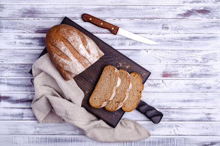 Traditional dark bread on a light wooden background. Top view.