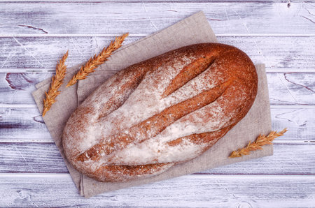 Traditional dark bread on a light wooden background. Top view.