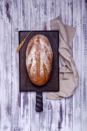 Traditional dark bread on a light wooden background. Top view.の写真素材