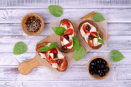Open sandwich with vegetables and cheese on a light wooden background. Top view. Selective focus.の写真素材