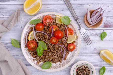 Salad with buckwheat and vegetables on a wooden background. Selective focus.の写真素材
