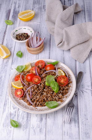 Salad with buckwheat and vegetables on a wooden background. Selective focus.の写真素材