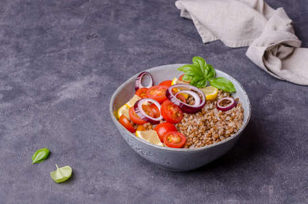 Salad with buckwheat and vegetables on a cement background. Selective focus.の写真素材