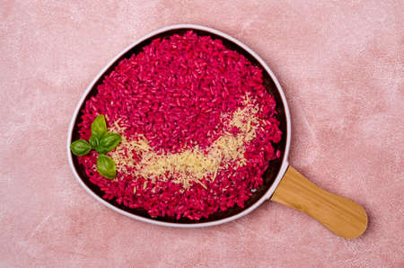 Beetroot risotto with cheese in a ceramic dish on a cement background. Top view. Selective focus.の写真素材