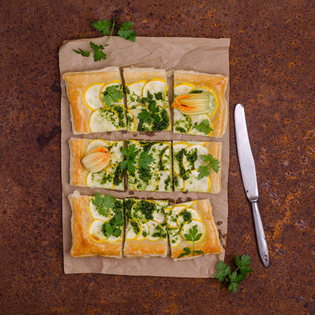 Square vegetable pie with green sauce on an old metal background. Top view. Selective focus.の写真素材