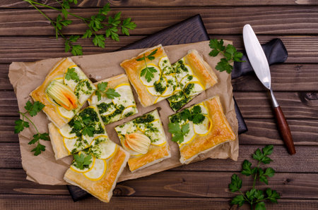 Round vegetable pie with green sauce on a wooden background. Top view. Selective focus.の写真素材