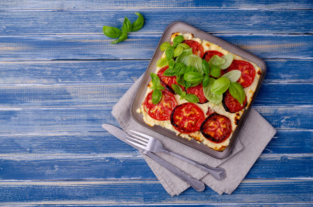 Tomato casserole with cheese on a wooden background. Selective focus.の写真素材