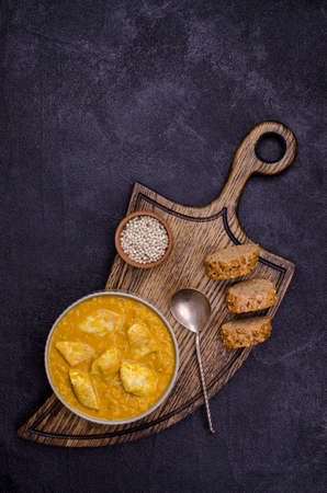 Curry with vegetables, lentils and meat on a black stone background. Selective focus. Top view.の写真素材