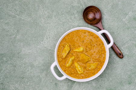 Curry with vegetables, lentils and meat on a green stone background. Selective focus. Top view.の写真素材