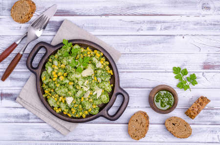 Gnocchi with corn and green sauce on a wooden background. Selective focus. Top view.の写真素材
