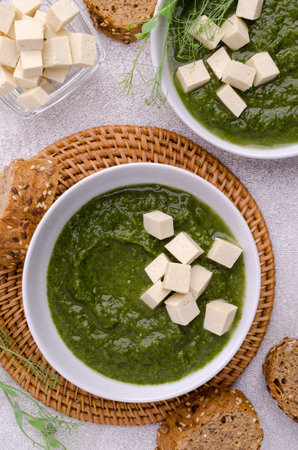 Green cream soup with slices of cheese and pea sprouts on a stone background. Selective focus.の写真素材
