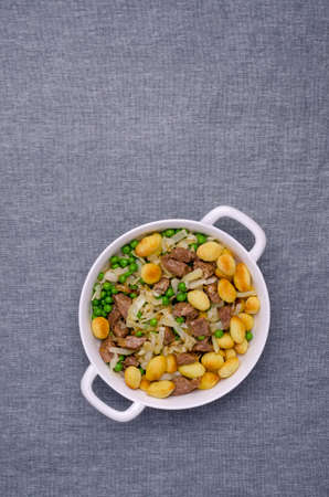 Baked gnocchi with stews and vegetables. Textile background. View from above.の写真素材