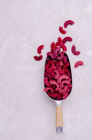 Dry traditional beetroot pasta. Stone background. Top view.の写真素材