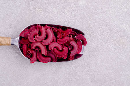 Dry traditional beetroot pasta. Stone background. Top view.の写真素材
