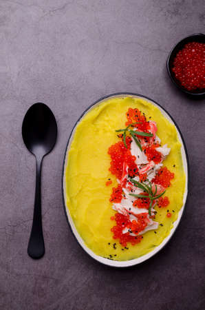 Yellow puree with crab meat and red caviar. Stone background. Selective focus.の写真素材
