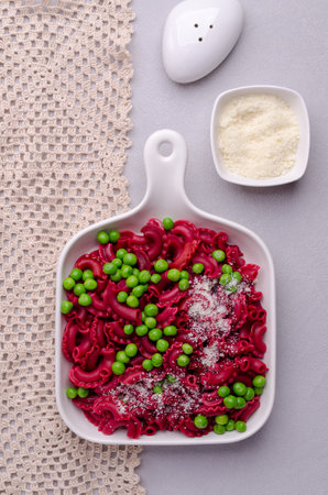 Beetroot pasta with green peas and cheese in a ceramic dish. selective focus.の写真素材