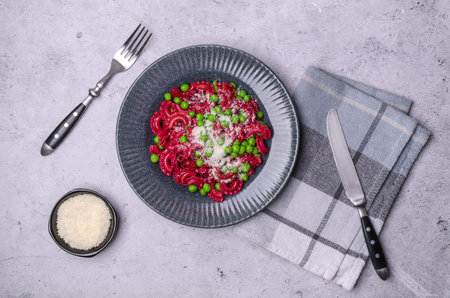 Beetroot pasta with green peas and cheese in a ceramic dish. selective focus.の写真素材