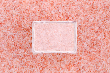 Pink salt crystals in a ceramic dish. top view. copyspace.