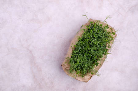 Organic fresh pea sprouts in a paper bag on a light background. selective focus. top view.の写真素材