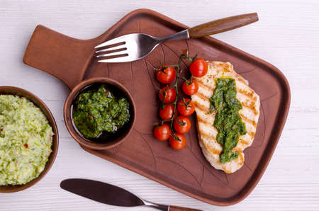 Grilled steak with green mashed potatoes and tomatoes on a light wooden background. top view.の写真素材