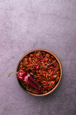 Crushed dry red pepper in a wooden dish. top view.の写真素材