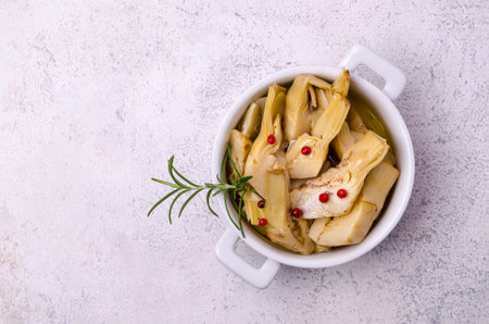 Slices of fried artichokes with spicy oil in a white ceramic dish. top view.の写真素材