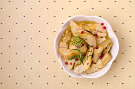 Slices of fried artichokes with spicy oil in a white ceramic dish. top view.の写真素材