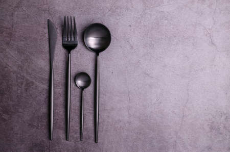 Clean black metal cutlery on a dark background. design concept. top view.の写真素材