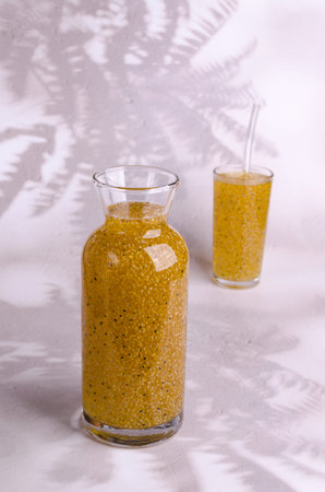 Yellow drink with seeds in a glass on a light background. selective focus.の写真素材