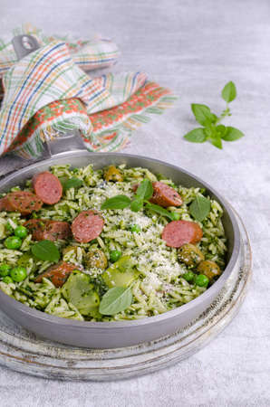 Pasta with vegetables and sausages in a metal frying pan on a light background. selective focus.の写真素材