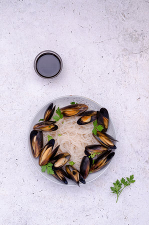 Pasta with mussels in a ceramic bowl on a light background. top view.の写真素材
