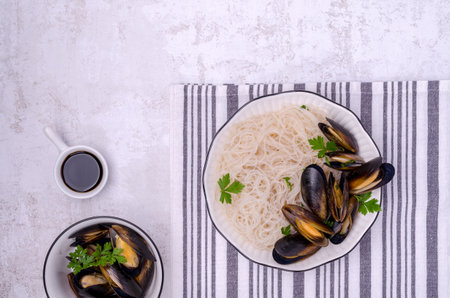 Pasta with mussels in a ceramic bowl on a light background. top view.の写真素材