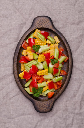 Salad fresh vegetables in a wooden dish on a crumpled textile background. top view.の写真素材