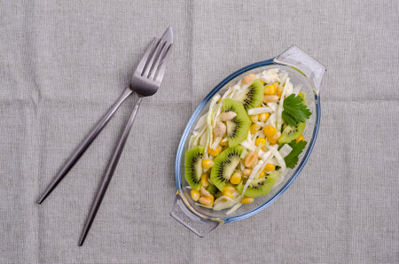 Fresh vegetables salad with kiwi in a dish on the table. top view.の写真素材