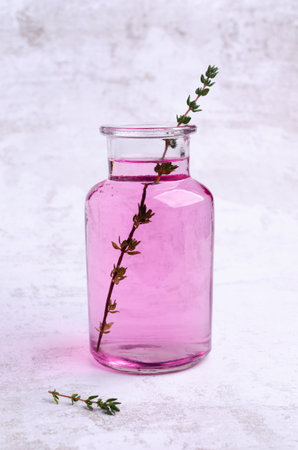 Pink drink with thyme in a glass on a light background. selective focus.の写真素材