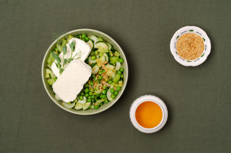 Salad green vegetables, white flax seeds and cheese slices on a textile background. top view.