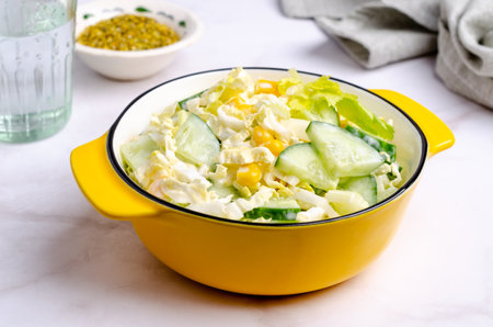 Raw vegetable salad with white sauce in a ceramic dish on a light background. selective focus.の写真素材