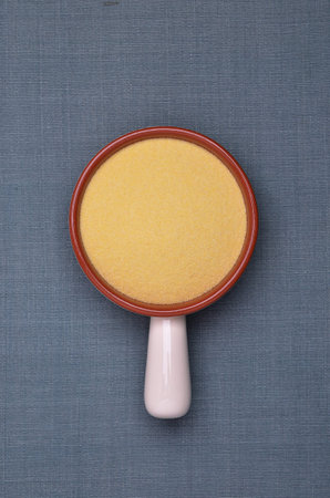 Durum wheat flour in a ceramic bowl on a textile background. Top view.の写真素材
